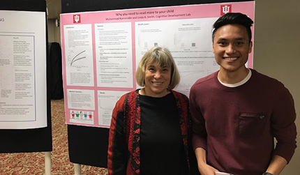 2 students in front of their poster