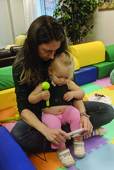 child wearing autonomic vest, sitting on mom's lap