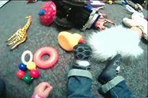 child viewing toys on floor