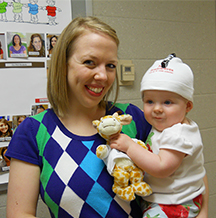 mom holding child wearing head camera