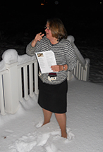 Susan Jones standing in snow and directing choir