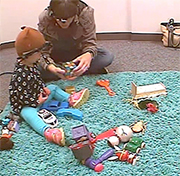 mom and child with head cameras on and playing with toys on the floor